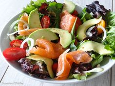 a salad with salmon, avocado and tomatoes