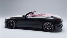 a black sports car with a pink top and leather seats is shown in front of a gray background