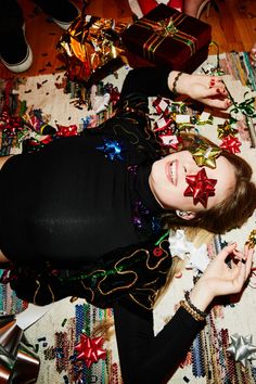 a woman laying on top of a rug covered in confetti