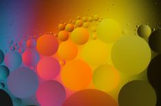 an abstract background with many different colored balls in the center and water droplets on the bottom