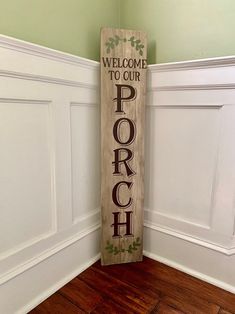 a wooden sign that says welcome to our porch on the corner of a room with wood flooring