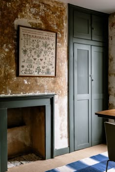 a room with a fireplace, chair and painting on the wall