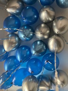 blue and silver balloons are hanging from the ceiling