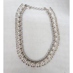 This is part of Chairish’s Costume Jewelry assortment.  1960s rhodium plated textured openwork articulated collar necklace with hook clasp. Marked "Monet" on a hangtag and "©" on the opposite side of the tag. Measures: 5 1/4 inches by 5 1/4 inches. Interior circumference on the largest setting is about 15 inches. Condition: Very good; it may have originally had a dangle at the end of the extension chain. Silver Chain Choker For Formal Occasions, Vintage Silver Adjustable Chain Necklace, Evening Jewelry With Lobster Clasp, Evening Metal Choker Chain Necklace, Retro Adjustable Silver Necklace, Silver Metal Formal Choker, Formal Metal Chain Choker, Formal Metal Costume Jewelry Choker, Silver Costume Jewelry Choker