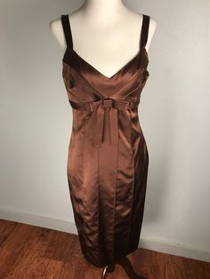 This is a sleek, beautifully tailored Betsey Johnson New York shift dress in satiny chocolate brown silk. It is sleeveless with straps and a side zipper. Flattering lines flow down the figure with beautifully tailored seams. The V shaped neckline is lined with matching facing and the bodice is crossed with more tailored seams. A sharp brown seamed ribbon goes around the dress under the bust line and features a pretty bow in front. It is in very good preowned condition. It is a size 8 but keep in Brown Spaghetti Strap Evening Dress, Formal Brown Dress With Fitted Bodice, Elegant Brown Dinner Dress, Elegant Brown Dress For Dinner, Brown Satin Party Dress, Brown Silk Cocktail Dress, Sleeveless Silk Brown Dress, Elegant Lined Satin Dress, Elegant Brown Lined Evening Dress