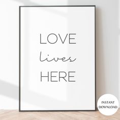 a black and white poster with the words love lives here written in cursive font