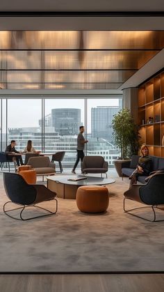 people are sitting in chairs and tables near large windows with cityscape behind them