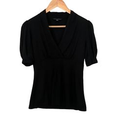 This Nwot Black Banana Republic Blouse Features An Empire Waist And Is Sewn To Look As Though It Wraps Over The Chest. It Is Made Of A Soft Fabric Consisting Of Cotton, Spandex, Rayon, And Tencel. The Sleeves Have A Very Slight Puff At The Shoulders And Gather Just Above The Elbow. Measurements Shown In Pictures. Features: Statement Sleeves Empire Waist Soft Fabric Business Casual Condition: Nwot Casual Fitted V-neck Blouse, Fitted Black V-neck Blouse, Fitted V-neck Casual Blouse, V-neck Knit Top For Summer Workwear, Fitted Short Sleeve V-neck Top For Work, Chic Black V-neck Top With Short Sleeves, Fitted Short Sleeve V-neck Top, Stretch V-neck Top For Work, Casual V-neck Fitted Blouse