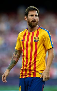 a soccer player with tattoos on his arm and chest stands in front of the crowd