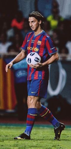 a man holding a soccer ball on top of a field