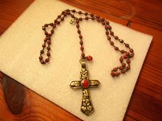 "This is a lovely, one of a kind piece. The spiritual necklace has a rosary chain comprised of beautiful marbled CORAL, CZECH, fire-polished, faceted rounds, secured with brass wire-wrapping. This ROSARY CHAIN is 26\" long (13\" drop without additional pieces). If you add the additional long drop of rosary chain, pendant and other embellishments, you gain an additional 6 1/2\" of length. At the 13\" drop point, the necklace chain joins into one piece of rosary chain, at the top of which is a gor Bohemian Crucifix Necklace As Gift, Bohemian Crucifix Necklace As A Gift, Spiritual Cross Necklace With Beaded Chain, Bohemian Crucifix Necklace, Red Spiritual Cross Pendant Jewelry, Bohemian Red Pendant Beads, Cheap Red Rosary With Round Beads, Adjustable Red Rosary With 8mm Beads, Red Adjustable Rosary With Round Beads