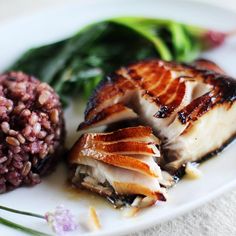 a white plate topped with meat and rice