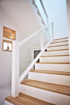 there is a white stair case with wooden steps