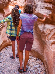 two women are standing in the middle of a canyon