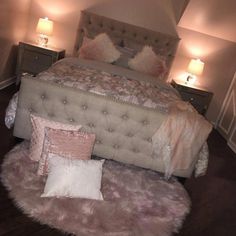 a bed with pink and white pillows on top of it