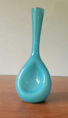 a blue vase sitting on top of a wooden table