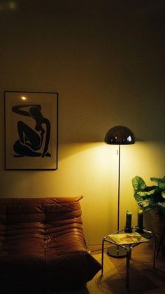 a living room filled with furniture and a lamp next to a painting on the wall