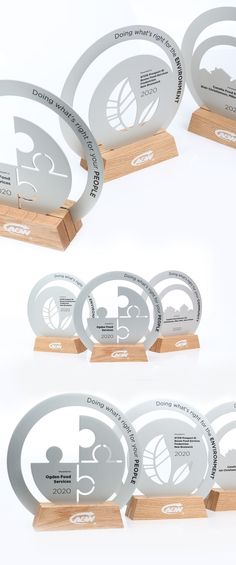 five trophies with wooden bases and metal numbers on them, all in different shapes and sizes