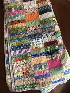 a multicolored patchwork quilt on a wooden table