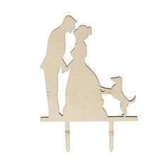 a wooden cutout of a man and woman holding hands with a dog on a table