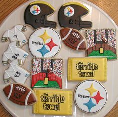 decorated cookies are arranged on a plate with footballs and other sports related items in the background