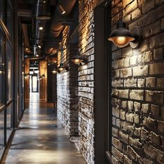 An industrial hallway with wall sconces mounted on exposed brick walls, the light highlighting the texture and depth of the brickwork2 Industrial Office Ideas, Industrial Corridor, Hallway Transformation, Black Wall Sconces, Corridor Lighting, Living Walls