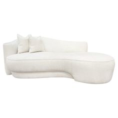 a white couch with two pillows on it's back and one arm folded up