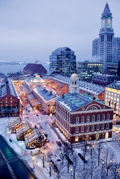 an aerial view of a city at night with snow on the ground and buildings in the background