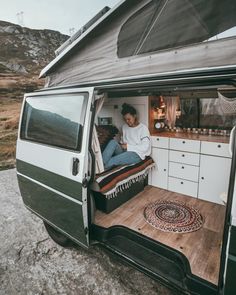 a woman sitting in the back of a van