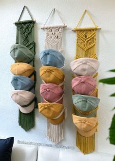 several hats are hanging on the wall with macrame beads and tassels