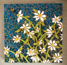 some white flowers and a yellow bee on a blue background with mosaic tiles in the middle