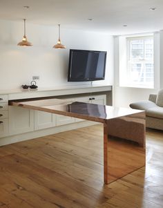 an open kitchen and living room with wood floors, white walls, and wooden flooring