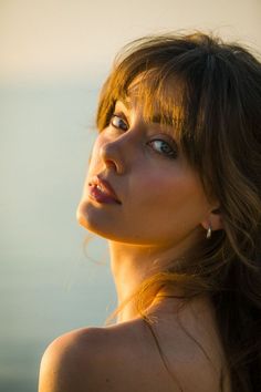 a woman with long hair looking off into the distance