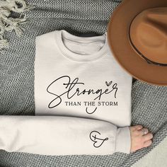 Stronger Than The Storm Sweatshirt, Inspirational Women Sweater, Strong Women Sweatshirt, Christian Sweatshirt, Bible Verse Sweatshirt,  Hi There!  We use one of the best quality t-shirt brands out there! Bella Canvas, Gildan Soft Style, Super comfy, cozy and oh so soft! :  * All Solid Color T-SHIRTS are 100% Cotton.  * All Heather Color T-SHIRTS and All Sweatshirts are combined with cotton and poly mix which makes them extra soft and so comfortable!s are combined with cotton and poly mix which makes them extra soft and so comfortable! * All of our shirts are Unisex and our sizes are Retail Fit. Taped shoulder to shoulder and side seamed. * Size tag labels are the free tear away kind so say bye to that unwanted itching!  So how will you order? 1- Choose Size 2- Choose Color 3- Add any pers Worship Craft, Stronger Than The Storm, Cross Shirt, Cross Shirts, Bible Verse Shirt, Woman Shirt, Women Sweatshirt, Christian Sweatshirt, Family Christmas Shirts