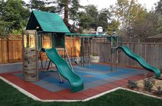 a play area with a slide and climbing frame in the back yard for children to play on