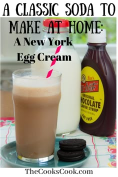 an egg cream milkshake and cookies are sitting on a table with the text, a classic soda to make at home a new york egg cream