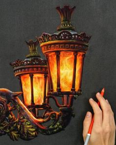 a person is drawing on a piece of paper with a light fixture in the background