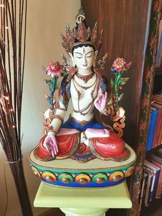 a buddha statue sitting on top of a table