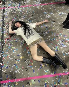 a woman laying on the ground surrounded by confetti