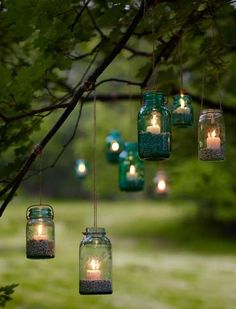 mason jars filled with candles hanging from a tree