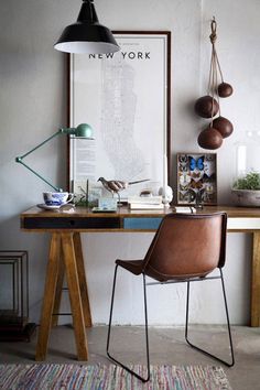 a desk with a chair, lamp and pictures on the wall