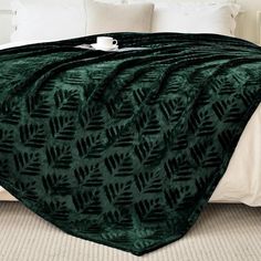 a bed with a green blanket on top of it