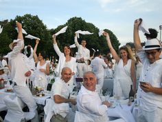 a group of people dressed in white throwing papers