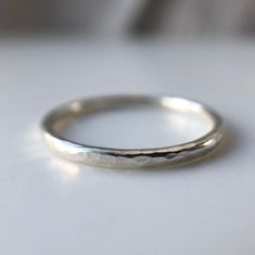 Galene - Greek Goddess of Calm Waters and Tranquillity. This Beautiful extra fine recycled silver band is perfect for stacking and looks equally beautiful as a stand alone ring. The soft organic hammered texture is inspired by reflections in calm water and creates a gorgeous shimmer in the light. Each ring is handmade to order by me from my workshop in Brighton. The delicate texture is hand applied making each ring completely unique in its beauty.  The ring is 1.5mm in width and is made using 10 Striling Silver Rings, White Gold Minimalistic Silver Ring, Silver Rings Basic, Silver Rings Handmade Minimalist, Brighton Rings Sterling Silver, Silver Liquid Ring, Handmade Rings Silver, Textured Wedding Band, Alternative Wedding Bands