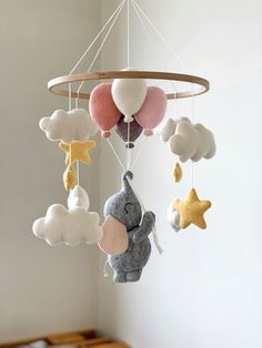 a mobile with stuffed animals hanging from it's sides in a nursery or child's room