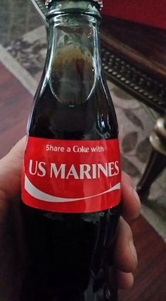 someone holding up a soda bottle that says us marines