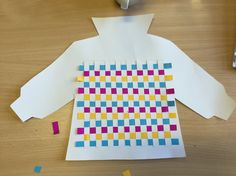 a piece of paper is cut out to look like a shirt with colorful squares on it