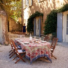 a woman standing in front of a table outside