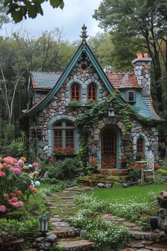 a stone house surrounded by flowers and greenery