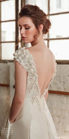 the back of a woman's wedding dress, with flowers on her neck and shoulders